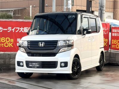 N-BOXカスタム　G・Aパッケージ　パール×ブラックの2トーンカラースタイル🔳　専用ブラックAWやブラックグリルなど装備もGood👍　バックカメラも付いていて駐停車も安心です🙌　フルセグTV視聴やBluetoothオーディオ接続可能のナビも付いています📱　🌜大阪店専用HPも要チェック❗carlifegroup.jp で検索🕵️‍♂️　Instagram・Twitter・TikTokも随時更新中❗❗🌛《1年保証付》