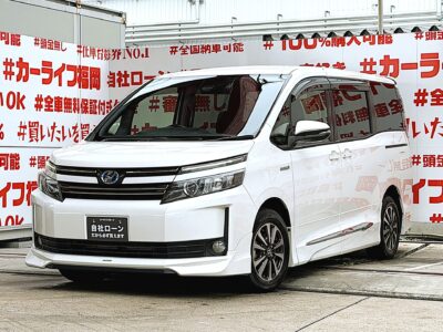 VOXY　ヴォクシー　ハイブリッドV【車検２年付】🔥純正オプションＴＲＤ・ハーフ３点エアロ装着でスタイリッシュ🔥💎純正９インチナビ🗾ＤＶＤ💿Ｂｌｕｅｔｏｏｔｈ🎶📱📞フルセグＴＶ内蔵型📺走行中映像視聴可能👀😲フリップダウンモニター＆天井スピーカでシアター空間の音響設定🎵夜間も明るいＬＥＤ💡ヘッドライトタイプ💡サイドシェードでＵＶ・プライバシーカット😎使い勝手の良い７人乗キャプテンシート・楽々ウォークスルー✨プリクラッシュセーフティーシステム・ＬＤＡ／衝突被害軽減ブレーキで運転支援装備も充実😲純正ドライブレコーダー付きで安心録画📹💎驚異のカタログ燃費🍃ＪＣ０８モード２３．８ｋｍ／Ｌ💎🚗福岡店専用HPでも在庫確認可能‼✨ 【carlifegroup.fukuoka.jp/】で検索🕵️‍♂️